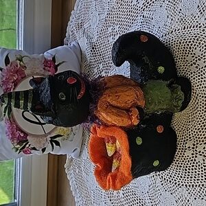 Halloween Cat is sitting on a witch's shoe.